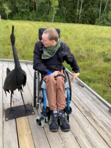 Poika pyörätuolissa ulkona terassilla